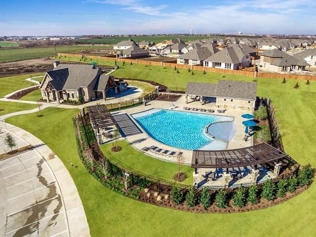 pool featuring a yard, a residential view, fence, and a patio