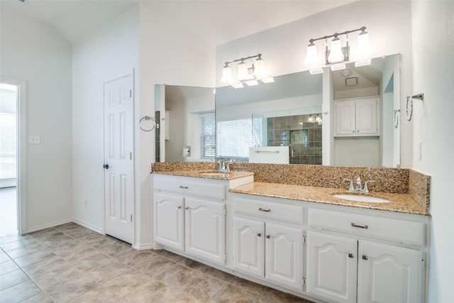 bathroom with tile patterned floors, an enclosed shower, vanity, and vaulted ceiling