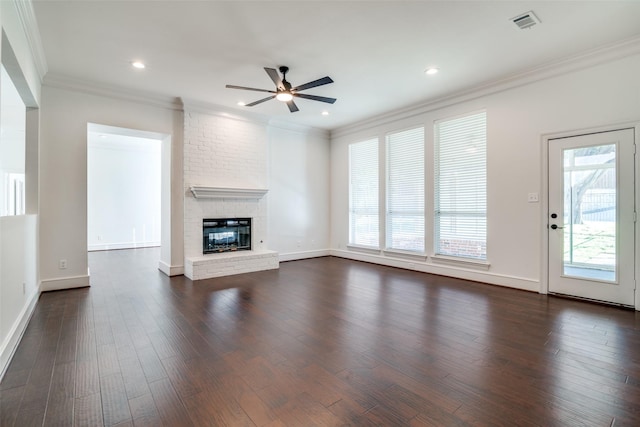 unfurnished living room with ceiling fan, a brick fireplace, ornamental molding, and dark hardwood / wood-style floors