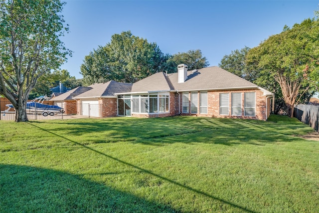 back of property with a yard and a sunroom