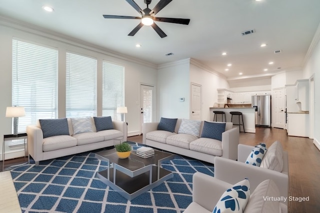 living room with ceiling fan, dark wood-type flooring, and ornamental molding