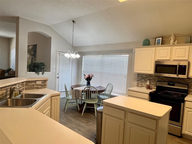 kitchen with white cabinets, a kitchen island, appliances with stainless steel finishes, and lofted ceiling