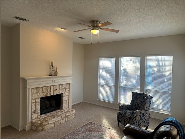 living room with a textured ceiling, carpet flooring, and ceiling fan