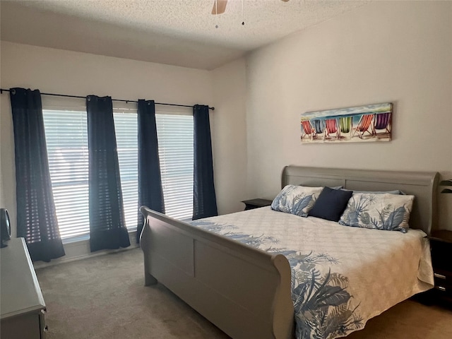 bedroom with multiple windows, a ceiling fan, carpet floors, and a textured ceiling