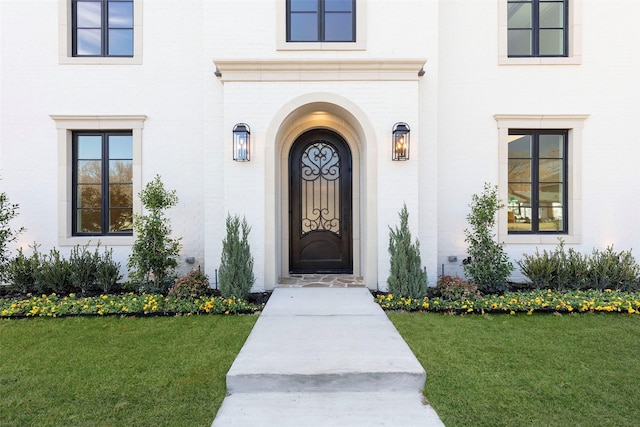 entrance to property featuring a lawn