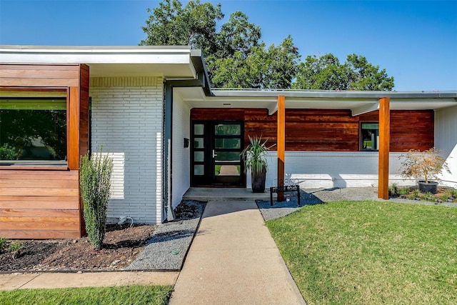 entrance to property with a lawn