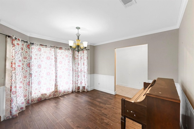 unfurnished dining area featuring ornamental molding, dark hardwood / wood-style floors, and a chandelier