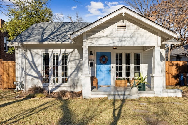 bungalow-style home with a front yard and french doors