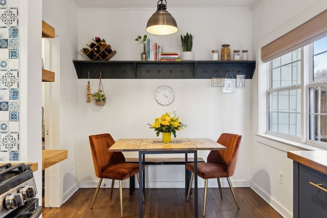 dining space featuring dark hardwood / wood-style floors, crown molding, and breakfast area