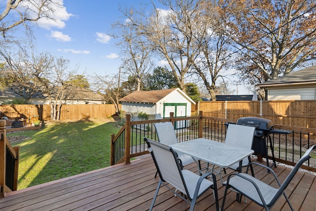 wooden terrace with a lawn, a storage unit, and grilling area