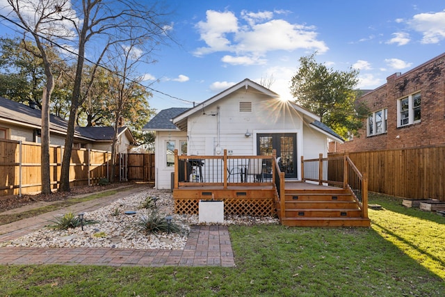 rear view of house with a deck and a lawn