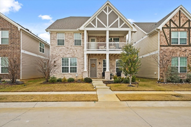 craftsman-style home featuring a front lawn and a balcony