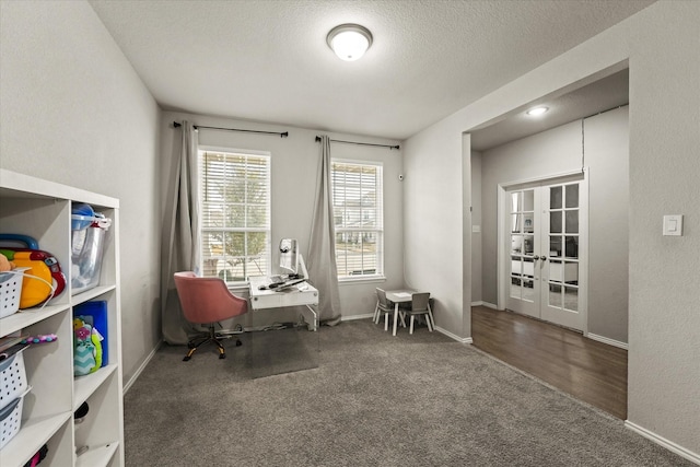 carpeted office with a textured ceiling and french doors