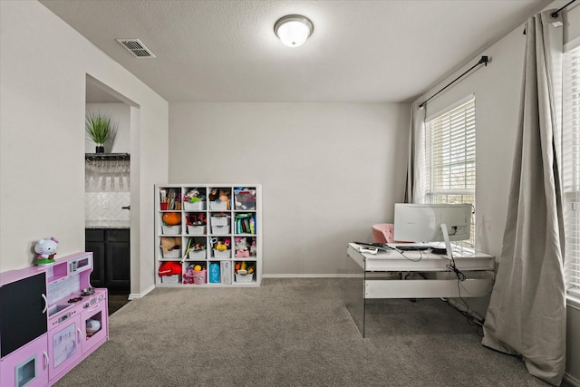 home office featuring dark carpet and a textured ceiling