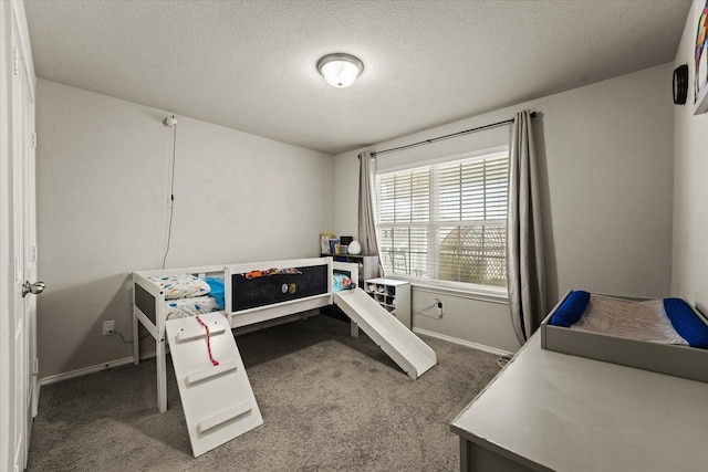 bedroom with a textured ceiling and dark carpet