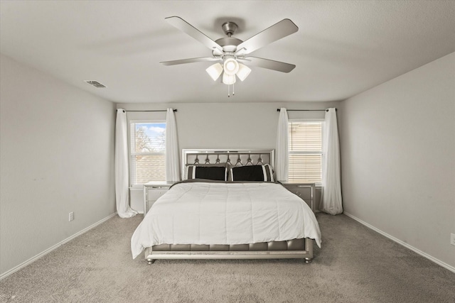 carpeted bedroom with ceiling fan and multiple windows