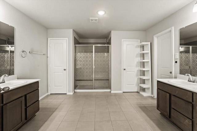 bathroom with a shower with door, tile patterned floors, and vanity