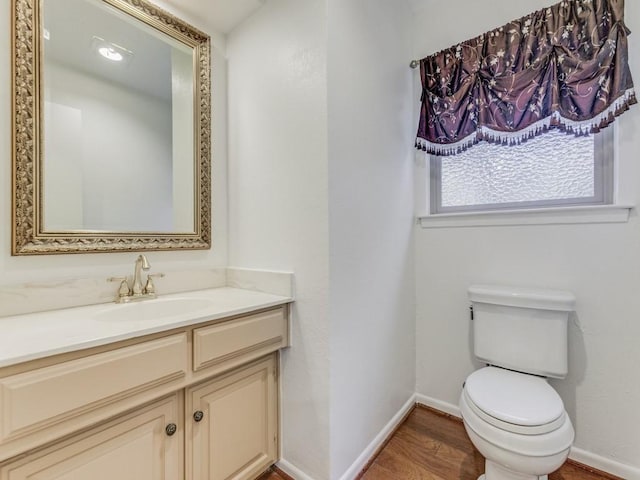 bathroom featuring toilet, vanity, and hardwood / wood-style floors