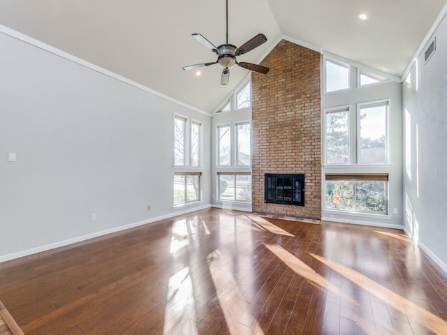 unfurnished living room with high vaulted ceiling, wood-type flooring, a brick fireplace, and plenty of natural light