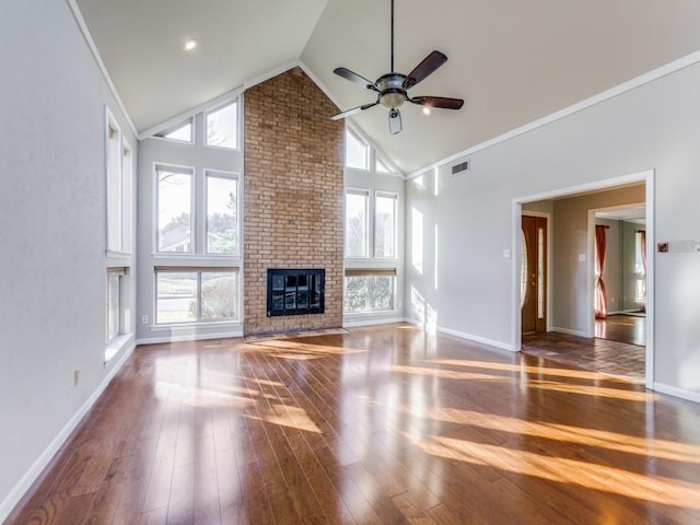 unfurnished living room with a healthy amount of sunlight, a fireplace, dark hardwood / wood-style floors, and high vaulted ceiling