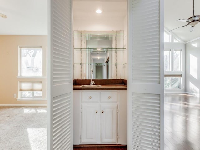 bar featuring lofted ceiling, carpet floors, white cabinetry, sink, and ceiling fan