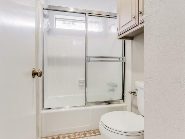 bathroom with tile patterned floors, enclosed tub / shower combo, and toilet