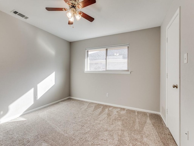 carpeted spare room featuring ceiling fan