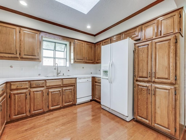 kitchen featuring decorative backsplash, sink, white appliances, and light hardwood / wood-style flooring