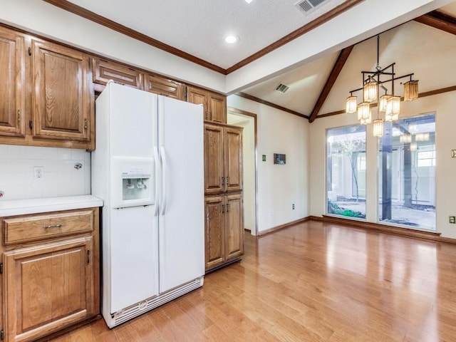 kitchen with backsplash, a notable chandelier, vaulted ceiling with beams, pendant lighting, and white refrigerator with ice dispenser