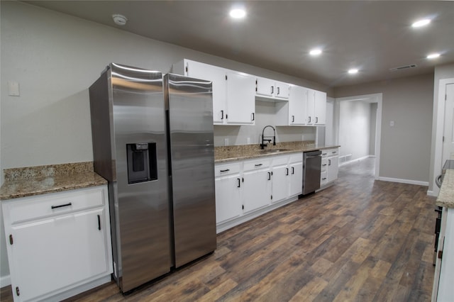 kitchen featuring sink, white cabinets, stainless steel fridge, and light stone countertops