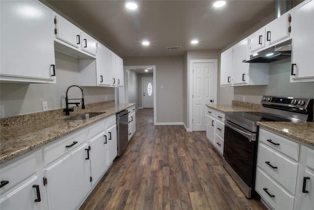 kitchen with white cabinets, appliances with stainless steel finishes, sink, and light stone counters