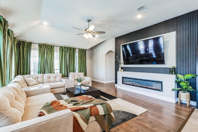 living room with ceiling fan, wood-type flooring, and lofted ceiling