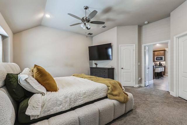 bedroom with ceiling fan, light colored carpet, and vaulted ceiling