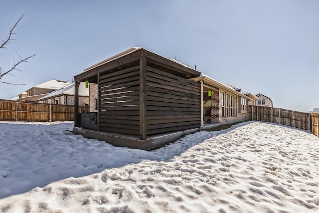 view of snow covered back of property