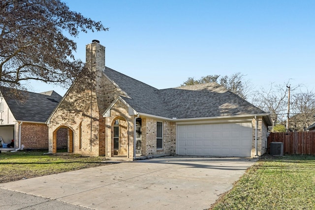 view of front of home with central AC unit, a garage, and a front yard