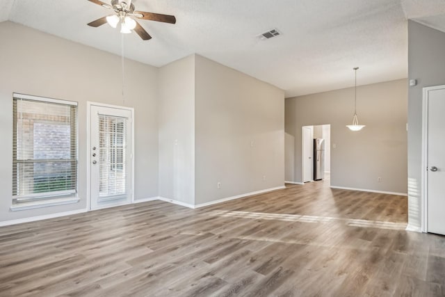 unfurnished living room featuring ceiling fan, wood-type flooring, a textured ceiling, and high vaulted ceiling