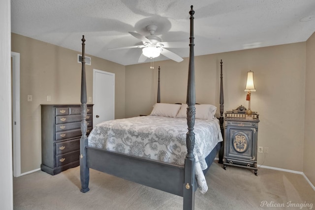 bedroom with ceiling fan, light carpet, and a textured ceiling