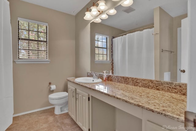 bathroom with toilet, vanity, and tile patterned flooring