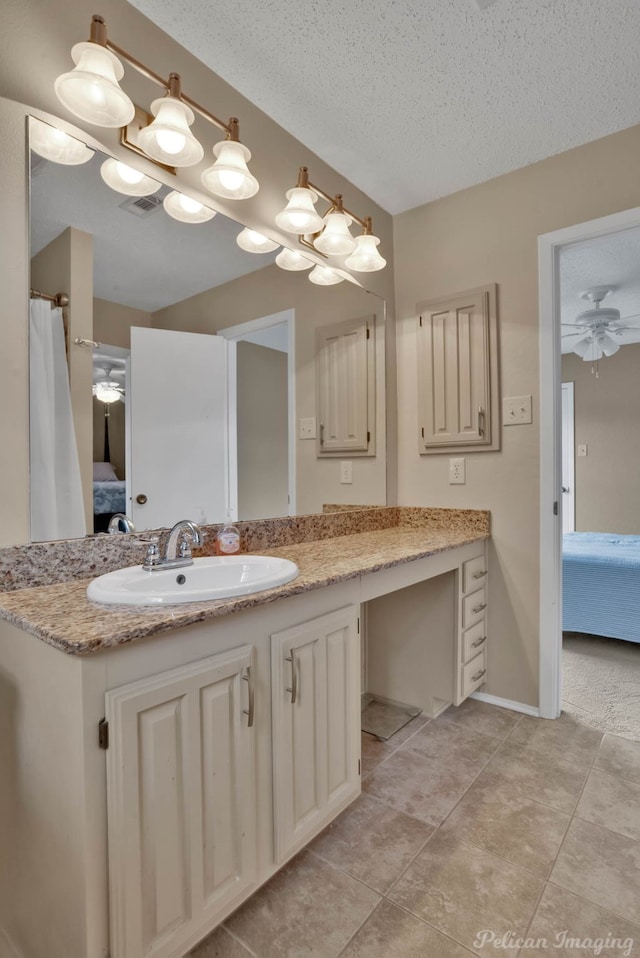 bathroom featuring ceiling fan, vanity, and a textured ceiling