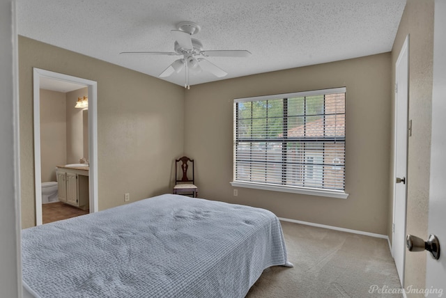 carpeted bedroom featuring ceiling fan, sink, connected bathroom, and a textured ceiling