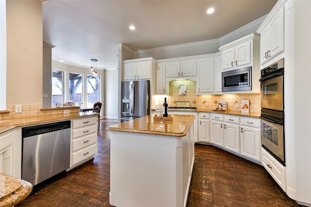 kitchen with stainless steel appliances, a center island, light stone countertops, and white cabinets