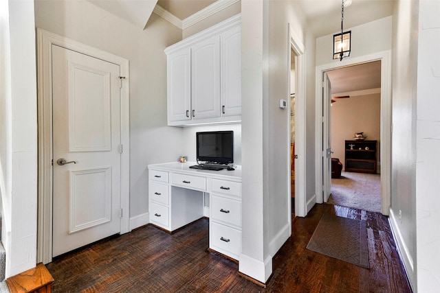 office area with crown molding, dark hardwood / wood-style floors, and built in desk