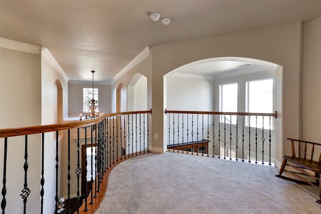 hallway with crown molding, carpet floors, a notable chandelier, and a textured ceiling