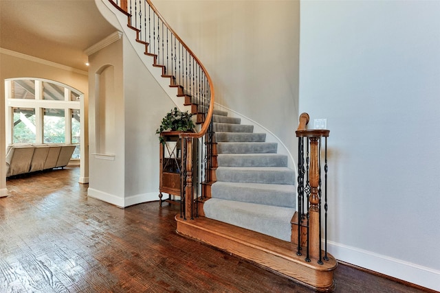 stairs featuring ornamental molding and hardwood / wood-style floors