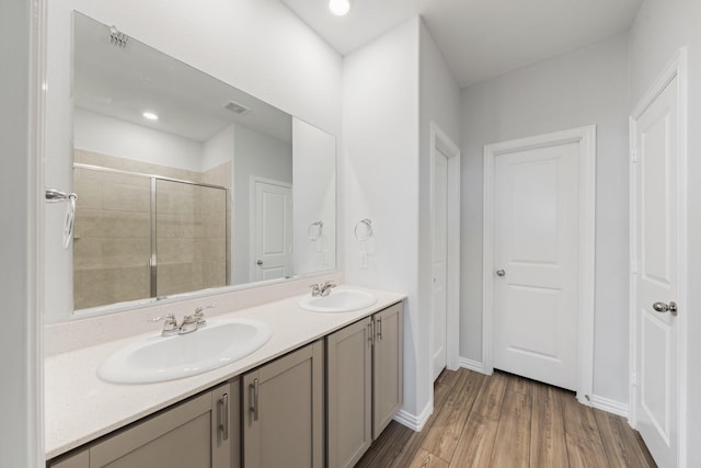 bathroom with vanity, hardwood / wood-style flooring, and a shower with door