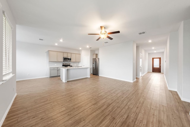 unfurnished living room with ceiling fan and light wood-type flooring