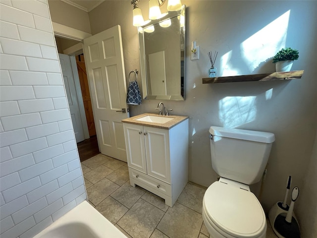 bathroom with tile patterned floors, vanity, toilet, ornamental molding, and a bathing tub