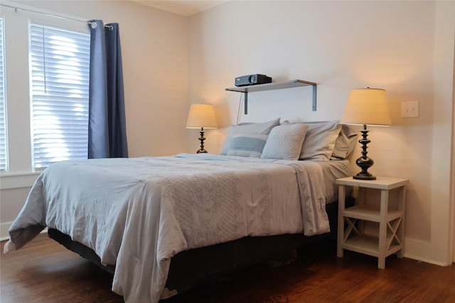 bedroom with dark wood-type flooring and multiple windows