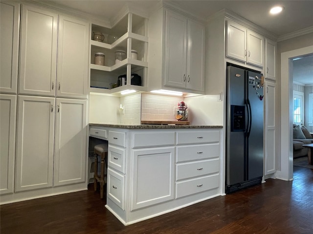 kitchen with white cabinets, stainless steel refrigerator with ice dispenser, dark hardwood / wood-style flooring, dark stone counters, and backsplash