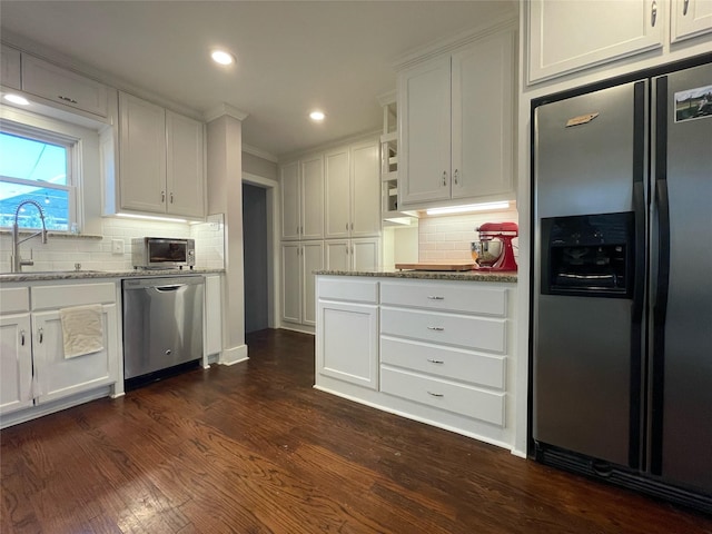 kitchen featuring appliances with stainless steel finishes, sink, light stone counters, and white cabinetry